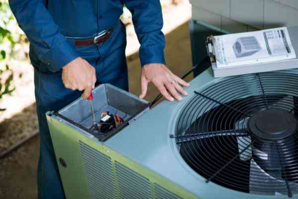 The Woodlands AC Repair employee performing AC maintenance for residential homeowner in The Woodlands, TX